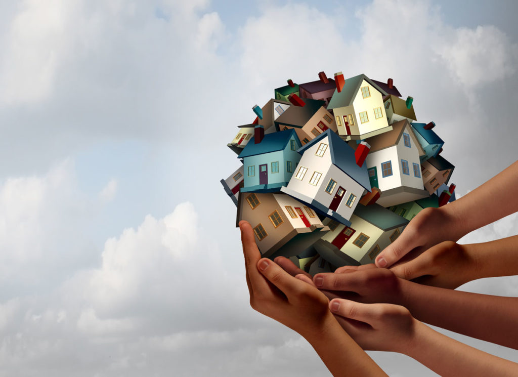 Investor hands holding a ball of affordable homes